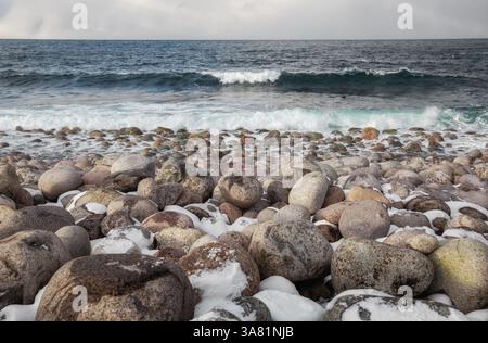 Teriberka, stone beach. The waves of the Barents Sea roll over the large oval boulders on the shore Stock Photo