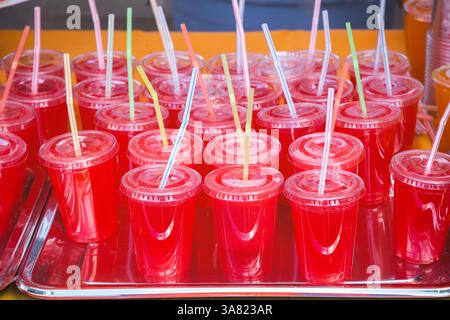 Watermelon fruit juice served in plastic cups with drinking straws at Brick Lane market in London Stock Photo