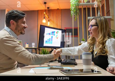 Businessmen shake hands after a successful results presentation Stock Photo