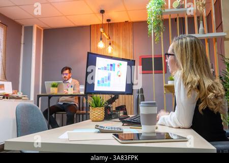 Business people working in an office analyzing financial charts Stock Photo