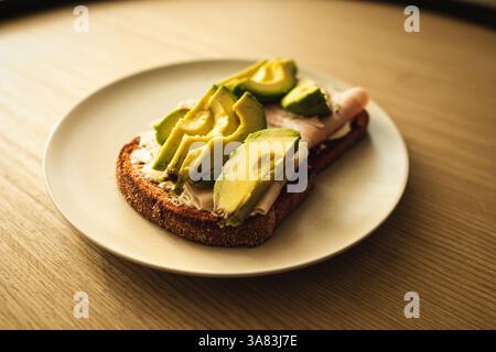 An avocado toasts over a wooden table Stock Photo
