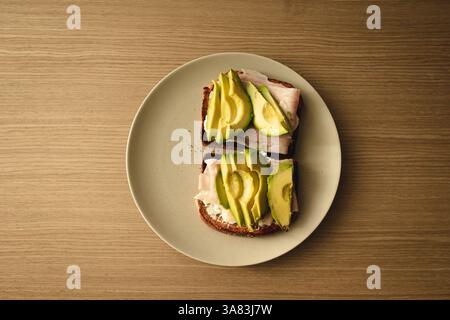 An avocado toasts over a wooden table Stock Photo