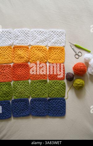 Crocheted squares blanket in making, multi-colored granny square Stock Photo