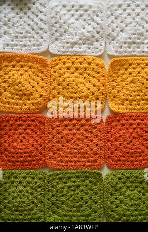 Crocheted squares blanket in making, multi-colored granny square Stock Photo