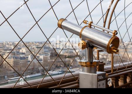 View of Paris. Telescope binoculars on the Eiffel Tower in Paris, France. Spyglass overlooking the beautiful sprawling cityscape buildings filled with Stock Photo