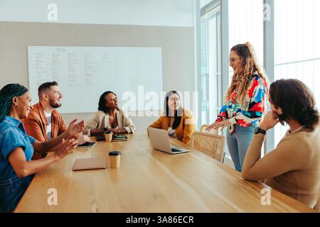 A diverse group of digital marketing professionals engaged in a meeting. The team is discussing strategies and ideas in an open environment. Stock Photo