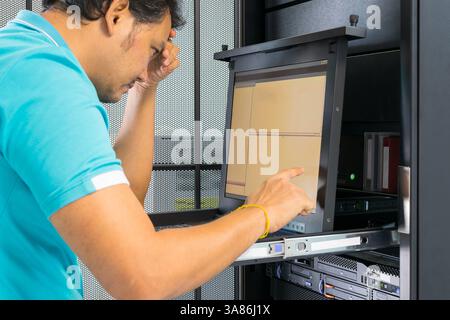 Asia man serious thinking when working on computer server Stock Photo