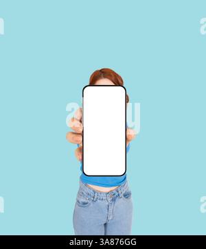 Application advertisement, app ad concept image woman holding showing smartphone with white blank device screen in hand close up to camera. Stock Photo