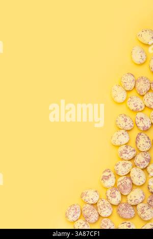 Vertical banner with small easter eggs on yellow background with empty space Stock Photo
