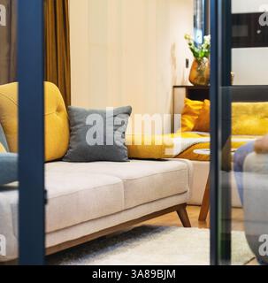 Couch with yellow and grey cushions in living room Stock Photo