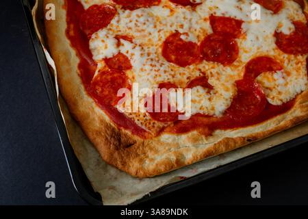 Gourmet pepperoni pizza in dark food style, highlighting its ingredients in a sophisticated setting. Stock Photo