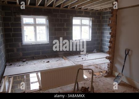 Construction site: An upper floor or attic conversion in progress, featuring new blockwork, windows, and exposed roof structure before completion. Stock Photo