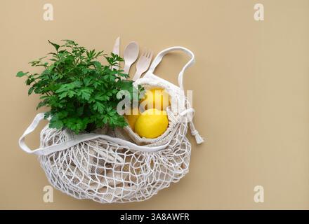 Fresh produce inside reusable mesh shopping bag on beige background with copy space Stock Photo
