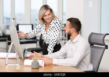 Technicians making digital engineering drawing on computer at desk in office Stock Photo