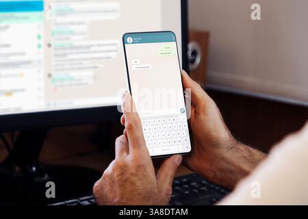 Man showing a phone in his hand and chatting app on the screen of smartphone. Communication Technology, application. Stock Photo