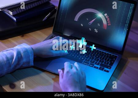 Bonus. Woman using laptop with gauge and percent signs on screen at table, closeup. Pluses over computer Stock Photo