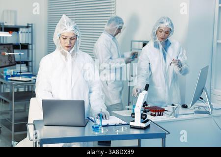 Scientists working with computers and samples in laboratory Stock Photo