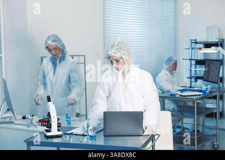 Scientists working with computers and samples in laboratory Stock Photo