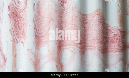 Close-up of a red and white textured surface with a wavy marbled pattern, ideal for artistic backgrounds and creative design projects. Stock Photo