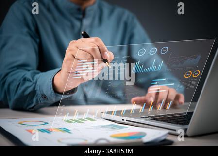 Businessman analyzing data on laptop for financial growth, marketing strategy, and investment planning in modern office with technology tools, charts, Stock Photo