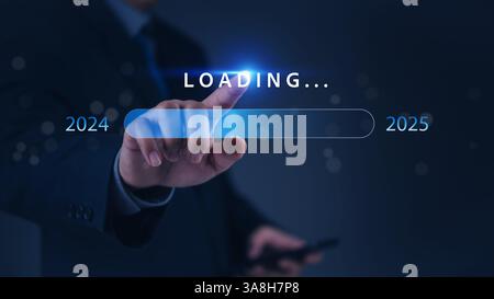 A hand pointing at a loading bar with a transition from 2024 to 2025 strategic planning, symbolizing progress and the future. Stock Photo