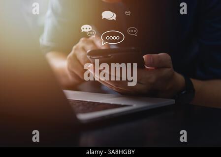 A person using a smartphone with chat icons floating, symbolizing online mobile technology, networking, and efficient communication in the digital wor Stock Photo