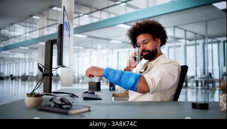 African American man with broken arm calling for worker's compensation. Stock Photo