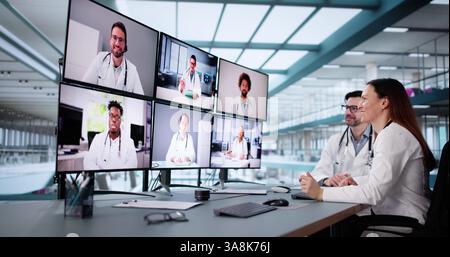 Male doctor in online video conference with female nurse on computer. Stock Photo