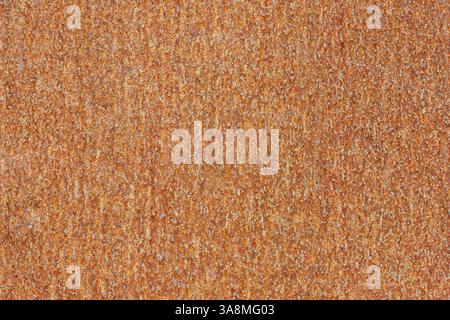 Close-up of a rusty metal plate showing rough texture and orange-brown hue, reflecting its weathered state in an urban setting. Stock Photo