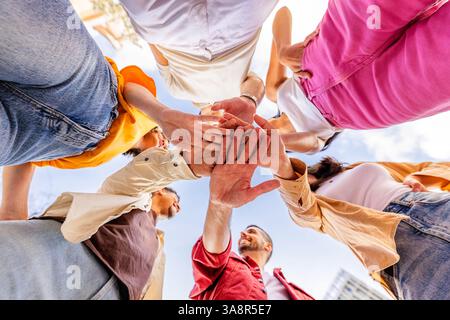 Multiracial happy friends stacking hands Stock Photo