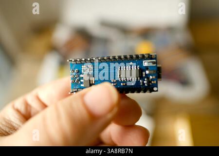 scientist, electronic engineer holds an electronic chip in hand, Electronics components, Breadboard in box with jumper wires and breadboard, electrica Stock Photo