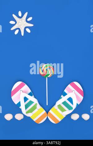 Summer rainbow flip flops, candy lollipop and seashells. Casual beach symbols and footwear for holiday season on blue background. Stock Photo