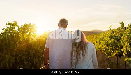 Travel, walking and back with old couple in vineyard for romance, anniversary date and bonding. Sunset, retirement and support with senior man and Stock Photo