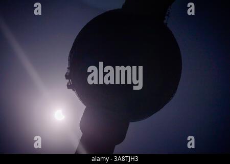 Berlin, Germany. 29th Mar, 2025. The partial solar eclipse can be seen behind the Berlin TV tower. In addition to Germany and large parts of Europe, the celestial event can also be observed from north-western Africa and northern Russia. Credit: Christoph Soeder/dpa/Ģ����ý Live News Stock Photo