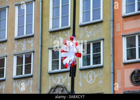 Gdansk, Poland - 11.11.2024: A Polish flag decoration attached to a lamppost on a historic street in Gdańsk on Poland National Day. Stock Photo