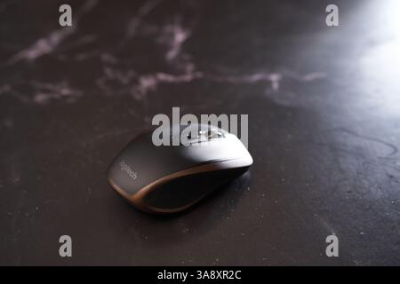 USA, Arizona - March 10, 2025: Logitech MX Anywhere 2 wireless mouse lies on a black table Stock Photo