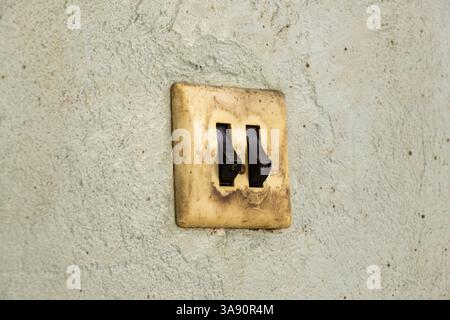 Old dirty double switch on old wall in workshop, wall switch Stock Photo