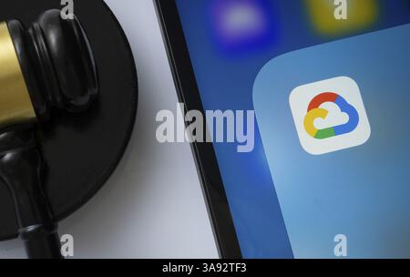 A close up of an iPad screen displaying the Google Cloud app alongside a judge's gavel Stock Photo
