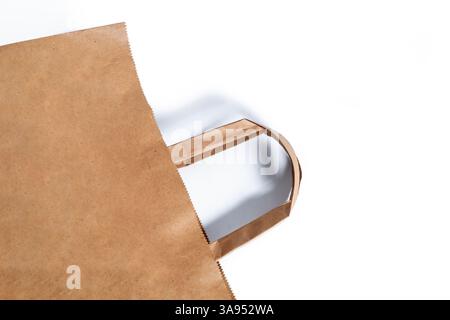 A close-up of a brown paper bag with handles, an eco-friendly alternative to plastic bags and a symbol of sustainability. Stock Photo