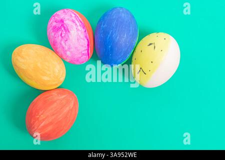 Brightly colored and decorated Easter eggs, illustrated on a solid green surface, evoke a festive atmosphere and holiday cheer. Stock Photo