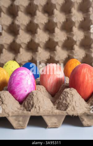 Vibrantly painted Easter eggs in recycled cardboard display creativity and celebration. holiday season. Stock Photo