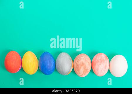 Vibrant and creatively painted Easter eggs, displayed in a horizontal row on a colorful background, evoke themes of celebration. Stock Photo