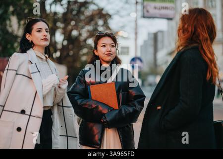 Three professional women collaborating outdoors in an urban setting Stock Photo