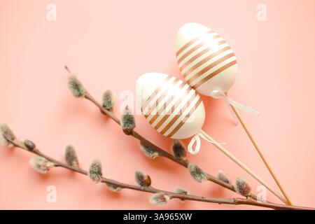 decorative easter eggs on sticks and willow branches, pink background Stock Photo