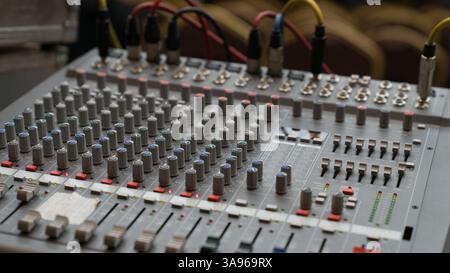 A professional audio mixing console with multiple knobs, buttons, and sliders, used for sound control in music production, broadcasting, and live even Stock Photo