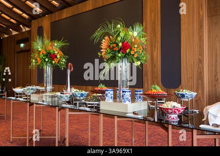 A beautifully arranged long table filled with a rich variety of Turkish cuisine, set for a festive banquet or celebration, adorned with elegant floral Stock Photo
