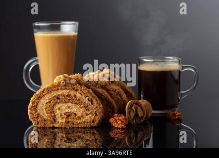 Walnut and buttercream roll: a traditional Oriental pastry. Dessert with walnuts and coffee on a black reflective background. Cake with brown sugar, w Stock Photo