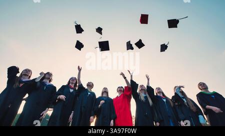 Cheerful students throwing graduation caps in the Air Stock Photo - Alamy