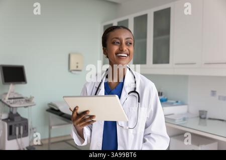 Positive young Black medical therapist woman using digital tablet Stock Photo