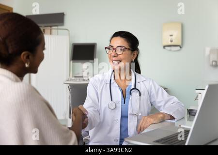 Positive doctor giving handshake to patient after consultation Stock Photo